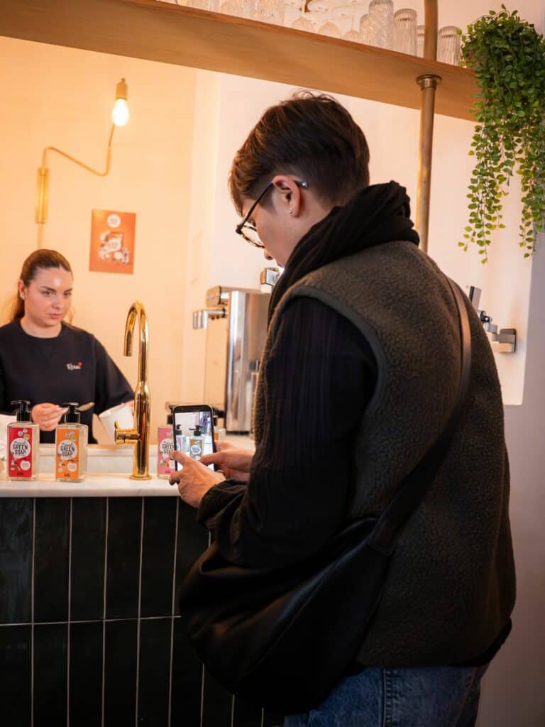 Créatrice de contenu photographiant les savons Marcel's Green Soap lors de l'événement de lancement
